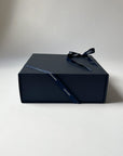 Navy blue gift box with a ribbon on a white background