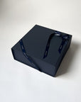 Dark blue gift box with a ribbon on a white background