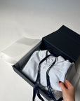 Striped pyjamas inside an open blue box on a light gray background