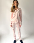 Woman wearing a pink pajama set against a plain background